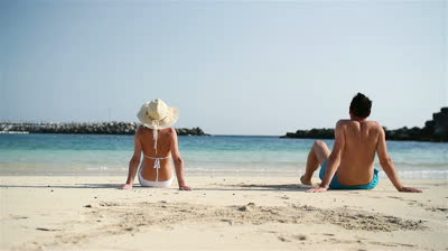 stock-footage-young-couple-sitting-on-beautiful-beach.jpg